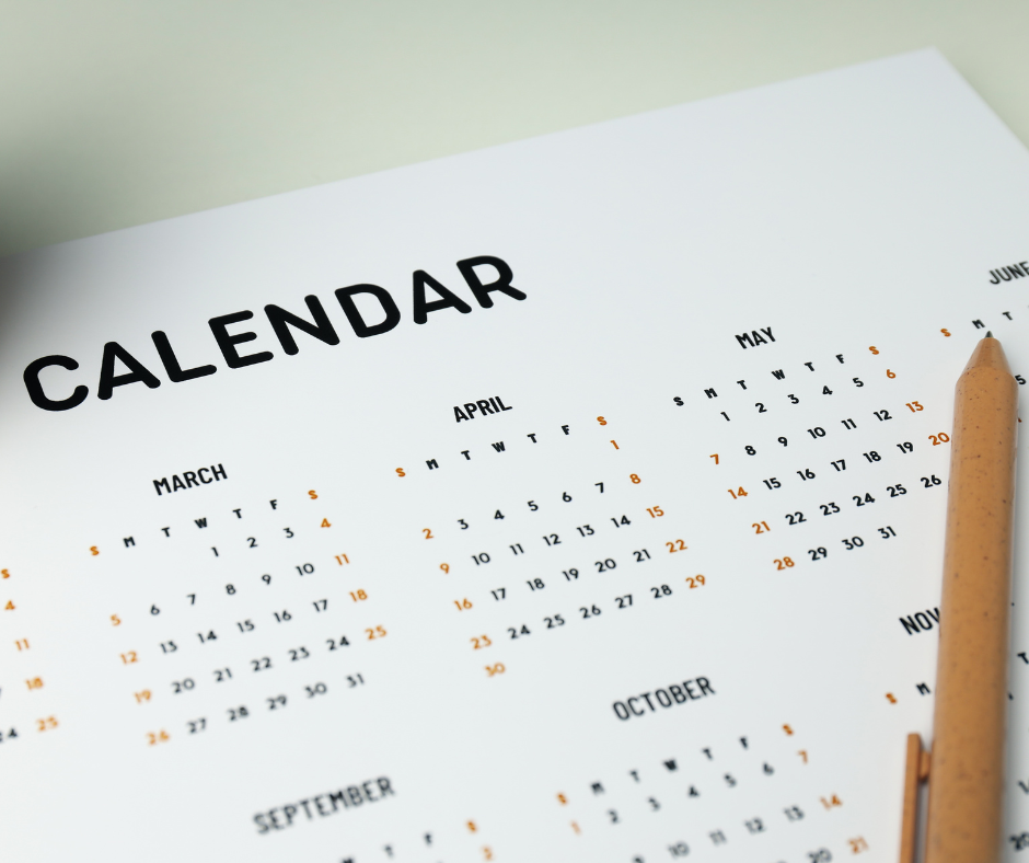 Paper depicting a calendar with a brown pen on top.