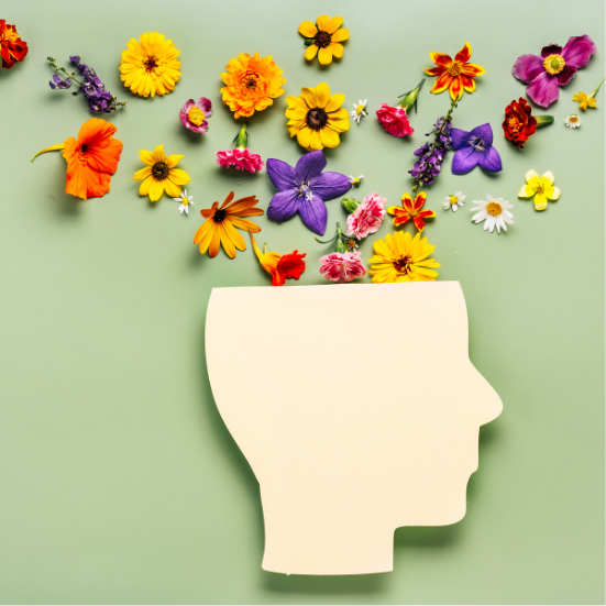 A green background with colorful flowers coming out of a cutout of a person's head