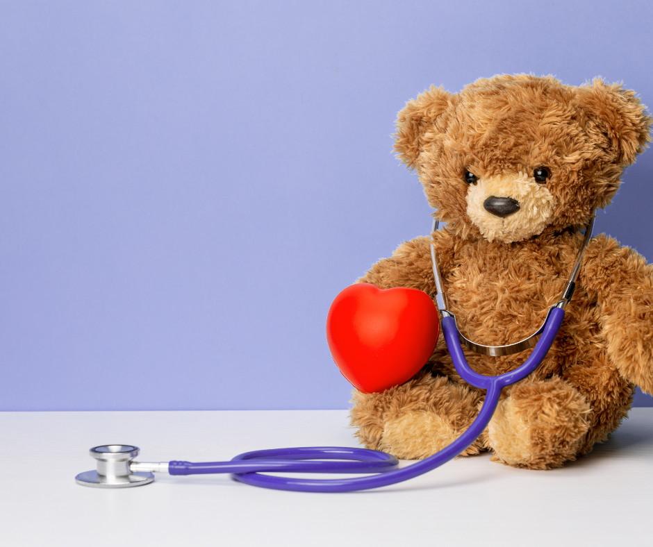 Teddy bear wearing a purple stethoscope with a heart in its right paw.