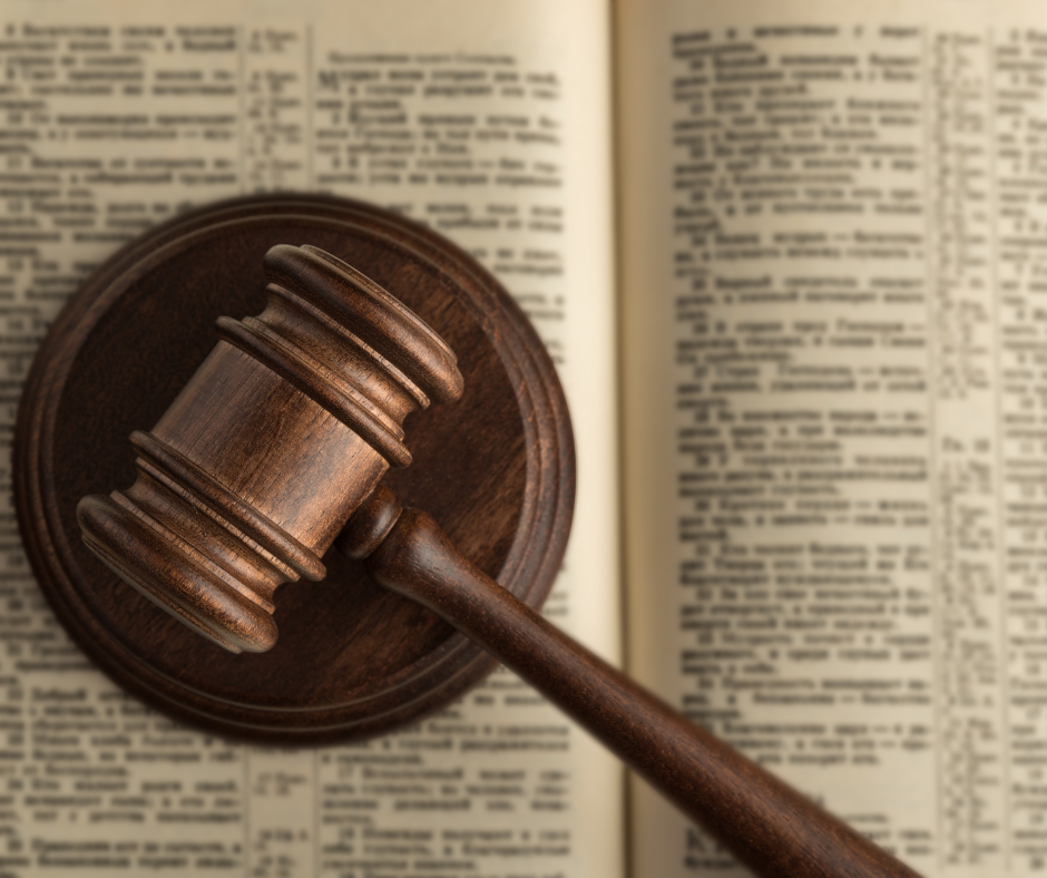 Wooden Gavel and sounding block on top of a book.