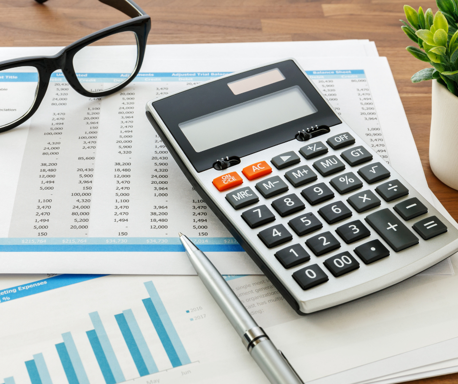 Calculator next to silver pen on top of 2 papers displaying a spreadsheet of numbers and blue bar graphs on top of a table.