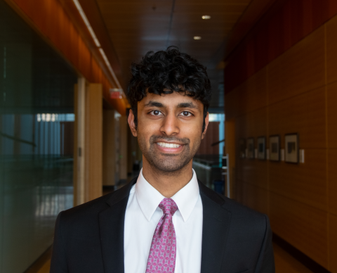 Man with black hair in a hallway