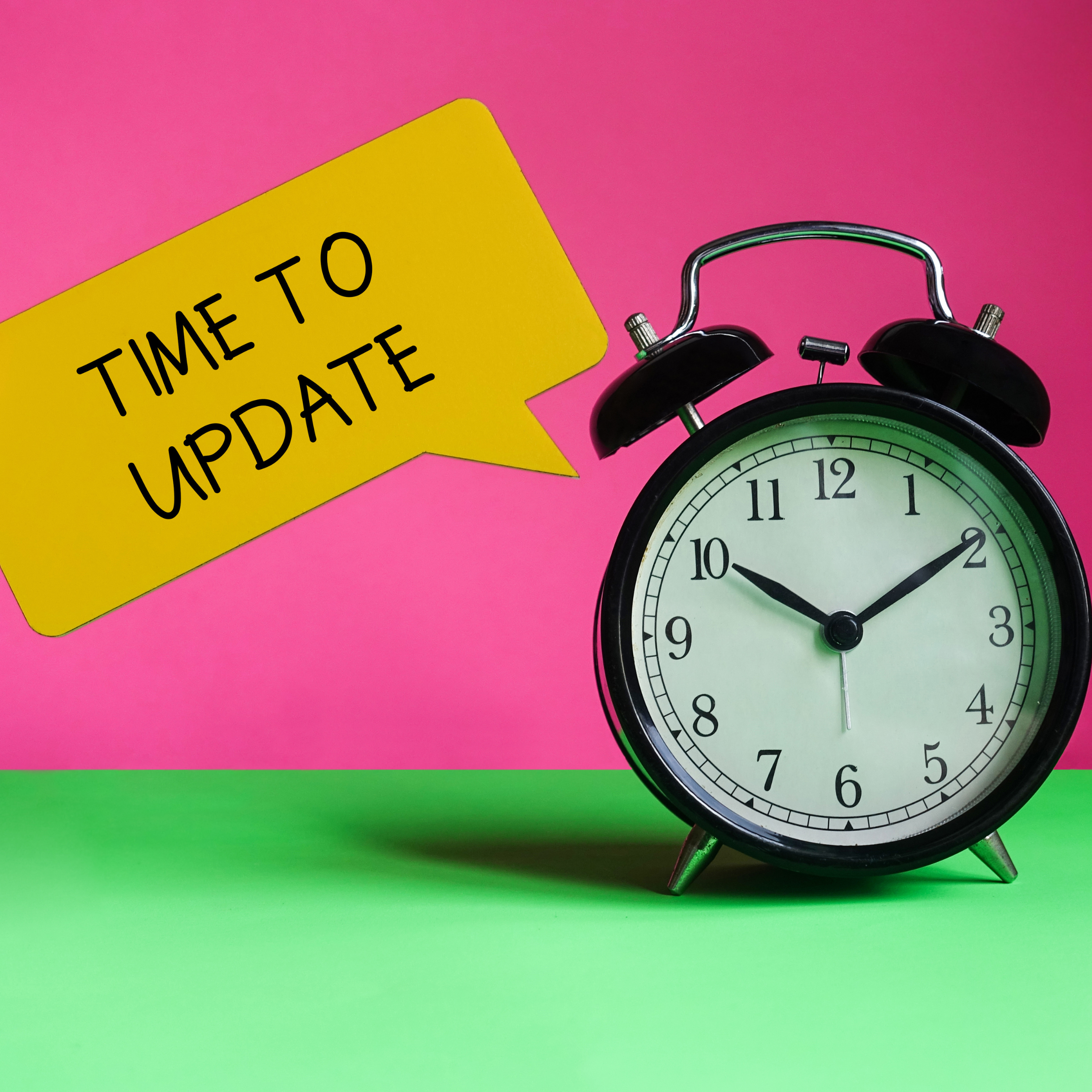 alarm clock on a pink and green background with a speech bubble stating "time to update"